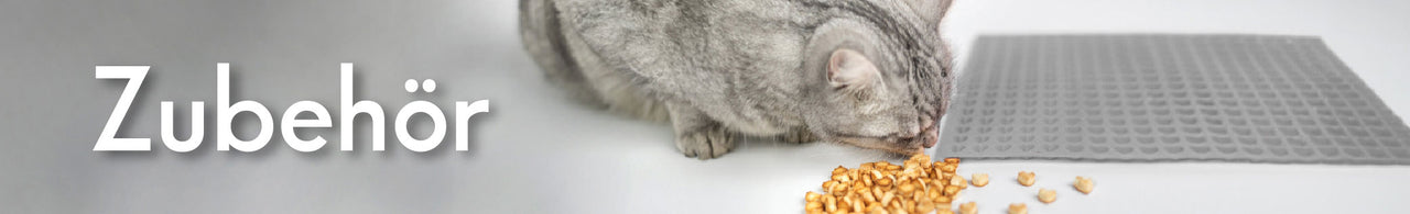 Zur Kategorie Zubehör für Katzen – Katze frisst neben einer Futtermatte. Jetzt Zubehör entdecken.