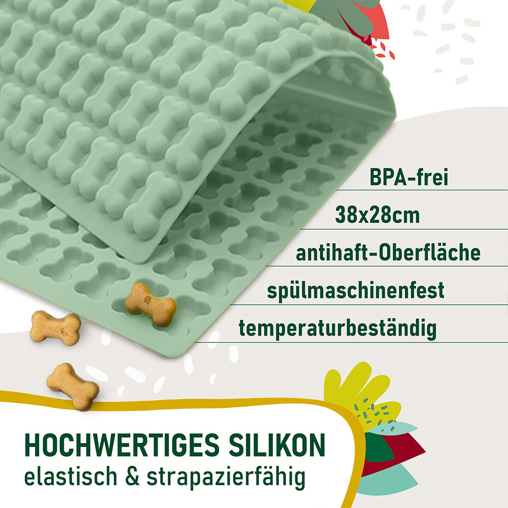 Trixie Backmatte (2cm Knochenform Grün), daneben kleine fertige Hundeleckerlis. Texthinweise auf dem Bild: BPA-frei, 38x28 cm, antihaft-Oberfläche, spülmaschinenfest, temperaturbeständig. Hochwertiges Silikon – elastisch & strapazierfähig.