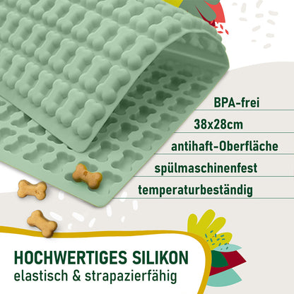 Trixie Backmatte (2cm Knochenform Grün), daneben kleine fertige Hundeleckerlis. Texthinweise auf dem Bild: BPA-frei, 38x28 cm, antihaft-Oberfläche, spülmaschinenfest, temperaturbeständig. Hochwertiges Silikon – elastisch & strapazierfähig.