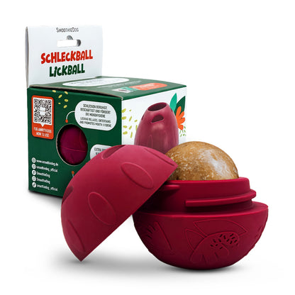 Geöffneter SmoothieDog Schleckball mit gefrorenem Snack im Inneren – befüllbares Schleckspielzeug für Hunde. Im Hintergrund sieht man einen Schleckball Einzeln in seiner Verpackung.